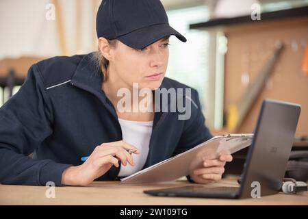 giovane donna che ripara apparecchiature elettroniche Foto Stock