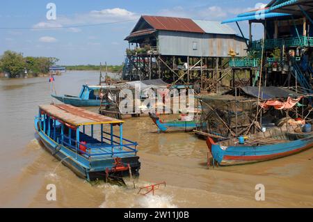 Barche che si muovono lungo i corsi d'acqua, il villaggio galleggiante Kampong Phluk nel lago Tonle SAP, Cambogia, Asia. Foto Stock