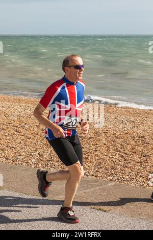 Inghilterra, Kent, Deal, Deal Beach, Jogger con Union Jack Tee Shirt Foto Stock