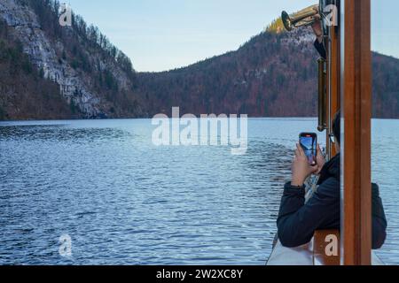 La gita in barca attraverso il lago Königssee ti porta oltre il muro Echo, famoso in tutto il mondo. L'autista della barca utilizza una tromba per mostrare l'eco sulla parete. Foto Stock