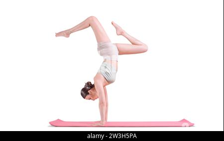 Giovane donna sportiva che pratica yoga. Sta tra le braccia su un tappeto rosso. Supporti misti Foto Stock