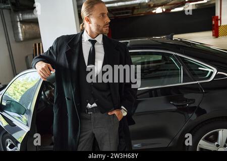 elegante ed elegante, professionale, con camice nero in posa con tasca nel parcheggio, business Foto Stock