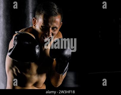 Lo sportivo professionista di arti marziali miste è in posizione di combattimento e batte il krim sul nemico. Vista frontale Foto Stock