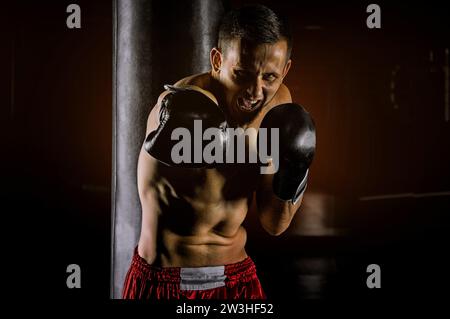 Lo sportivo professionista di arti marziali miste è in posizione di combattimento e batte il krim sul nemico. Vista frontale Foto Stock