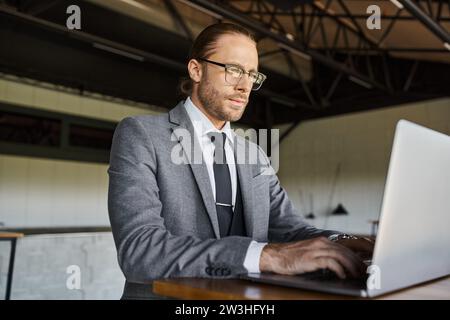 elegante e professionale con occhiali in astuta che lavorano sul suo laptop, concetto aziendale Foto Stock