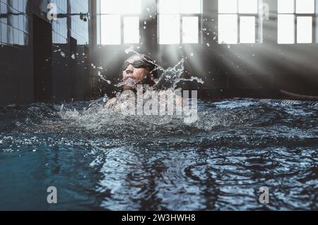 L'atleta professionista nuota nella breaststroke in piscina. Supporti misti Foto Stock