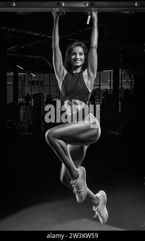 Charming Woman si tira al bar. Il concetto di sport, palestre, abbigliamento sportivo, fitness. Prepararsi per la gara. Supporti misti Foto Stock