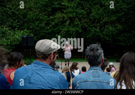 Momento affascinante all'interno di una folla animata, ipnotizzato da un vivace attore comico drag, che delizierà un pubblico di tutte le età con umorismo e stile. Foto Stock