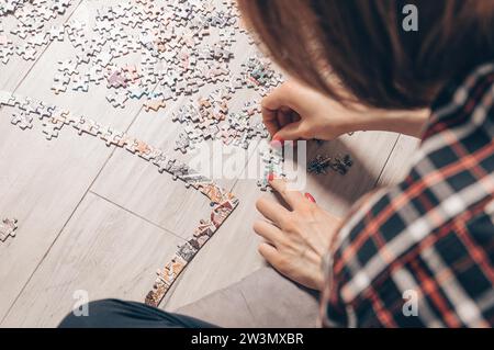 L'adolescente gioca a rompicapo. Il concetto di giochi da tavolo educativi. Resta a casa. Supporti misti Foto Stock