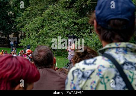 Momento affascinante all'interno di una folla animata, ipnotizzato da un vivace attore comico drag, che delizierà un pubblico di tutte le età con umorismo e stile. Foto Stock