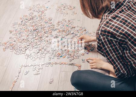 L'adolescente gioca a rompicapo. Il concetto di giochi da tavolo educativi. Resta a casa. Supporti misti Foto Stock