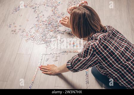 L'adolescente gioca a rompicapo. Il concetto di giochi da tavolo educativi. Resta a casa. Supporti misti Foto Stock