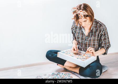 L'adolescente gioca a rompicapo. Il concetto di giochi da tavolo educativi. Resta a casa. Supporti misti Foto Stock