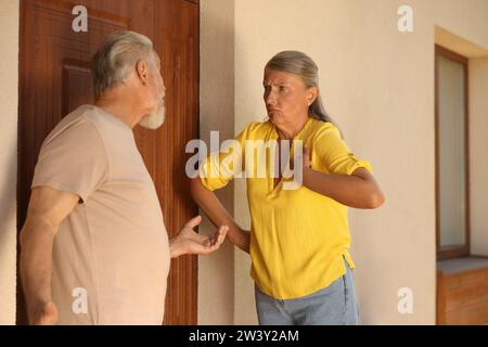 Vicini emotivi che discutono vicino alla casa all'aperto Foto Stock