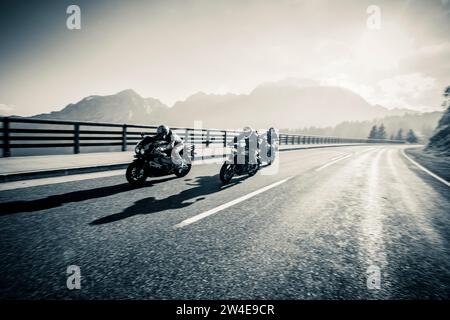 Tre motociclisti sulla strada panoramica Rossfeld con l'Hoher Goell sullo sfondo Foto Stock