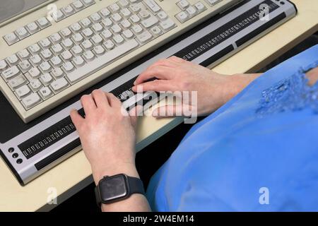 Blinde Frau arbeitet mit einer Braillezeile. Die Braillezeile, kurz Zeile, oder Brailledisplay ist ein computer-Ausgabegerät für blinde Menschen, das Foto Stock