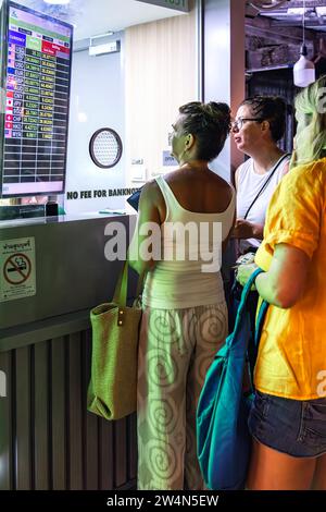 Turisti che cambiano denaro al banco di cambio valuta di notte, mercato dei pescatori, Bo Phut, Ko Samui, Thailandia Foto Stock