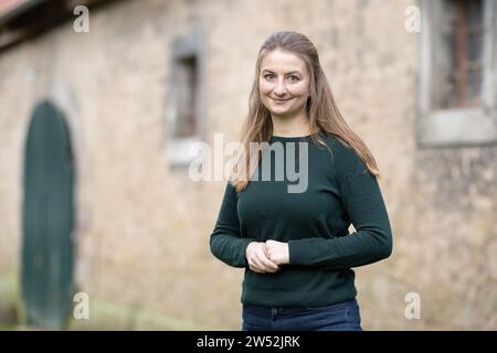 21 dicembre 2023, bassa Sassonia, Göttingen: Marie von Schnehen, contadina, si trova di fronte a un fienile nella fattoria tradizionale Hofgut Klein-Schneen vicino a Friedland. L'agricoltore ha avviato una petizione che invita il governo federale a mantenere l'esenzione dalla tassa sui veicoli in agricoltura e lo sconto sul gasolio. Foto: Swen Pförtner/dpa Foto Stock