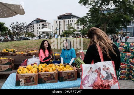 Raanana, Israele. 21 dicembre 2023. I volontari vendono prodotti agricoli dalle comunità di frontiera di Gaza in un mercato all'aperto ad hoc nella città centrale israeliana di Raanana a sostegno degli agricoltori sfollati dalle loro case dal 7 ottobre 2023. Gran parte del raccolto è fatto anche da volontari in uno sforzo in modo da salvare ciò che può essere salvato. Oltre 60.000 residenti delle comunità di frontiera di Gaza sono stati costretti a evacuare le loro case a seguito di un massiccio fuoco missilistico dalla Striscia di Gaza in Israele il 7 ottobre 2023, infiltrazione di uomini armati nel territorio israeliano, massacro di circa 1.400 donne civili e Foto Stock