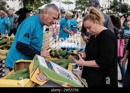 Raanana, Israele. 21 dicembre 2023. I volontari vendono prodotti agricoli dalle comunità di frontiera di Gaza in un mercato all'aperto ad hoc nella città centrale israeliana di Raanana a sostegno degli agricoltori sfollati dalle loro case dal 7 ottobre 2023. Gran parte del raccolto è fatto anche da volontari in uno sforzo in modo da salvare ciò che può essere salvato. Oltre 60.000 residenti delle comunità di frontiera di Gaza sono stati costretti a evacuare le loro case a seguito di un massiccio fuoco missilistico dalla Striscia di Gaza in Israele il 7 ottobre 2023, infiltrazione di uomini armati nel territorio israeliano, massacro di circa 1.400 donne civili e Foto Stock