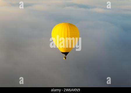Vista spettacolare della mongolfiera gialla che vola sopra il cielo nuvoloso a Teotihuacan, Messico Foto Stock