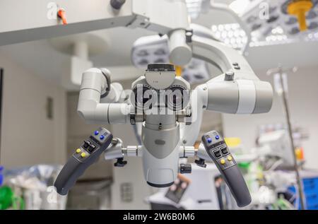 Primo piano del moderno microscopio con lente e monitor posizionati in laboratorio su sfondo sfocato in ospedale Foto Stock