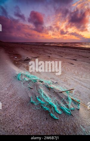 Rete da pesca lavata su una spiaggia al tramonto, Curonian Spit, Mar Baltico, Lituania Foto Stock