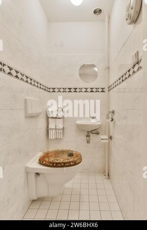 WC in legno e lavandino in ceramica nel lussuoso bagno piastrellato bianco del moderno appartamento Foto Stock