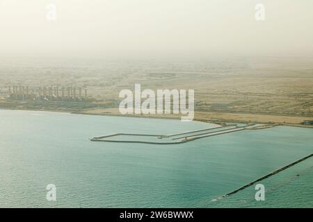 Vista aerea di una raffineria di gas naturale liquido e di una centrale elettrica sulla costa di Doha, Qatar, sul Golfo Persico, vista dall'alto in una giornata di fumo Foto Stock