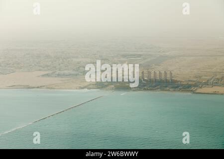 Vista aerea di una raffineria di gas naturale liquido e di una centrale elettrica sulla costa di Doha, Qatar, sul Golfo Persico, vista dall'alto in una giornata di fumo Foto Stock