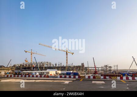 Nuovi lavori di costruzione in corso e gru a torre gialle Liebherr presso l'aeroporto internazionale Hamad di Doha, Qatar, Medio Oriente Foto Stock
