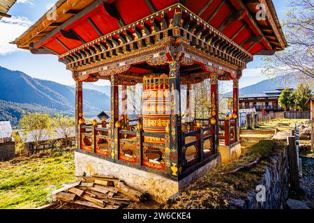 Una tipica ruota di preghiera buddista nel villaggio di Nubding che si affaccia sulla valle di Phobjikha nel distretto di Wangdue Phodrang nel Bhutan centrale Foto Stock