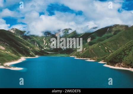 Cielo blu e paesaggio marino turchese con montagne e nuvole bianche Foto Stock