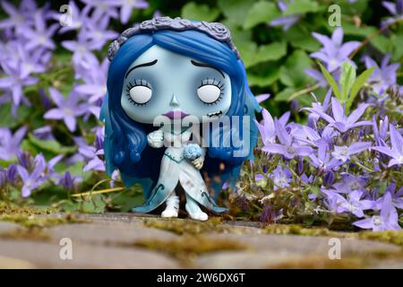 Funko Pop action figure di Emily dal film d'animazione dark fantasy Corpse Bride. Fiori blu, muschio, strada di pietra, giardino misterioso, matrimonio. Foto Stock