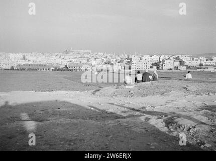 Persone sedute su una collina che guardano la città di Aleppo con la cittadella sopra ca. 1950-1955 Foto Stock