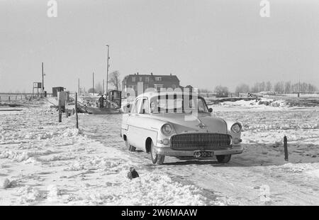 Attraversa il fiume ghiacciato a Wijhe in auto, ca. 15 gennaio 1963 Foto Stock