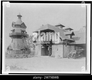 Il mulino a vento a forma di torre orologio a sinistra e parte del garage di Edmund Cogswell Converse, con due uomini in automobile a destra, Greenwich, Connecticut Foto Stock