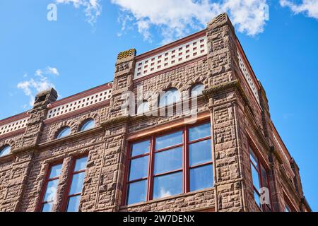 Maestoso edificio in pietra d'epoca con finestre ad arco e merlature, angolo basso Foto Stock