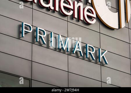 Il logo Primark dell'azienda di fast fashion. Il rivenditore di abbigliamento e accessori si trova in un centro commerciale. Pubblicità sull'edificio. Foto Stock