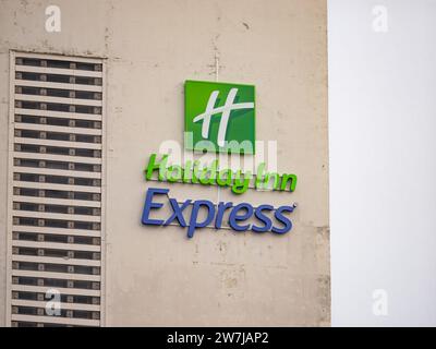 Cartello con il logo dell'Holiday Inn Express sulla facciata di un edificio con le intemperie. La società di ospitalità fa parte del business InterContinental Hotels Group. Foto Stock