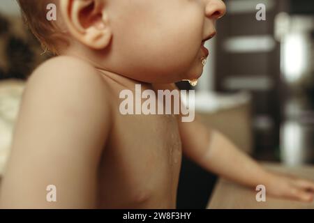 Primo piano della saliva sulla parte inferiore del viso di un bambino piccolo Foto Stock