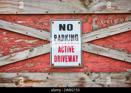 Cartello bianco senza parcheggio attivo con vernice nera e rossa su sfondo in legno testurizzato Foto Stock