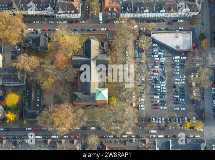 Vista aerea, immagine verticale di St Chiesa di Michele in Michaelplatz con parcheggi, circondati da alberi decidui autunnali, Wanheimerort, Duisburg, Foto Stock