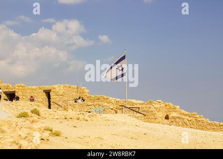 Il 2022 novembre, la bandiera israeliana vola con orgoglio mentre i turisti visitano Massada, costruita da Erode il grande, e l'antico sito della rivolta ebraica contro la R. Foto Stock