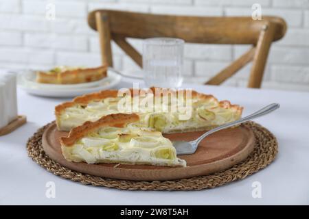 Tavola con gustosa torta di porri e torta sul tavolo Foto Stock