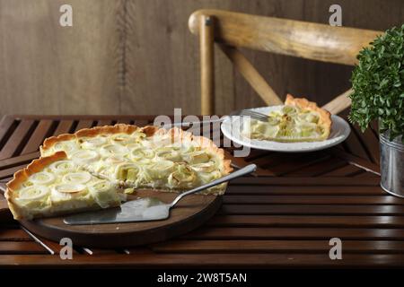 Gustosa torta di porri servita su un tavolo di legno Foto Stock