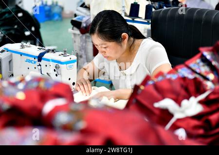 Caoxian, provincia cinese di Shandong. 6 luglio 2023. Un membro dello staff cucì Hanfu nella contea di Caoxian, nella provincia di Shandong della Cina orientale, 6 luglio 2023. PER ANDARE CON 'Across China: East China County Graced, Empowered by Hanfu' credito: Guo Xulei/Xinhua/Alamy Live News Foto Stock