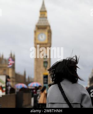 Londra, Regno Unito. 21 dicembre 2023. Una donna cammina sul Westminster Bridge a Londra, in Gran Bretagna, 21 dicembre 2023, mentre Storm Pia porta venti forti in molte parti del Regno Unito e causa interruzioni dei trasporti in tutto il paese. Crediti: Li Ying/Xinhua/Alamy Live News Foto Stock