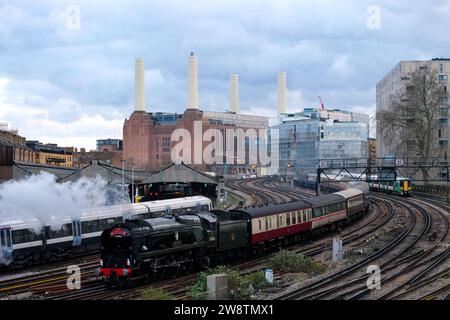 Londra, Regno Unito. 16 dicembre 2023. Il Santa Steam Express, un viaggio in treno a tema festivo popolare tra le famiglie, sfuma mentre parte da Victoria Station. Due servizi speciali - un treno a vapore e lussuose escursioni gastronomiche operate dalla Victoria Station di Londra in vista del Natale, dove passarono la Battersea Power Station, illuminata al tramonto in poi con un design festoso dell'artista David Hockney. Credito: Fotografia dell'undicesima ora/Alamy Live News Foto Stock