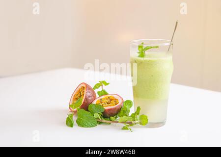 Frullato vegetariano con foglie di menta e frutto della passione in vetro isolato su sfondo bianco Foto Stock